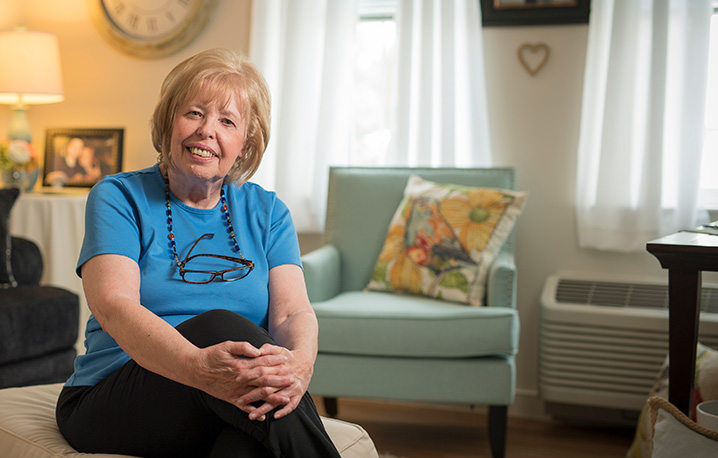 Elderly woman in a blue shirt sitting in living room