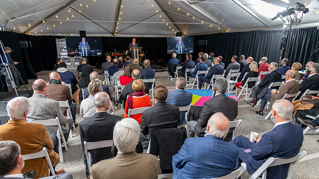 3 speakers on a stage in front of an audience
